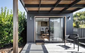 a house with a glass door on a patio at Modern Studio with Outdoor Bath and Cabin Sauna in Albion Park +4 photos