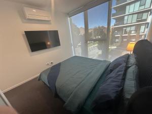 a bedroom with a bed and a flat screen tv at Prime CBD central 3bedroom apartment in Canberra +29 photos