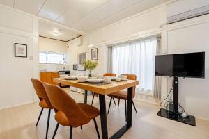 ein Esszimmer mit Tisch und Stühlen und einem Fernseher in der Unterkunft Higashi tateishi Kodate HTI1 in Tokio