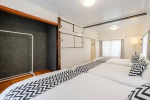 zwei Betten in einem Zimmer mit einer Tafel an der Wand in der Unterkunft Higashi tateishi Kodate HTI1 in Tokio