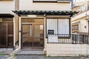 eine Tür eines Gebäudes mit einem Schild davor in der Unterkunft Higashi tateishi Kodate HTI1 in Tokio