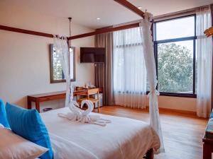 a bedroom with a bed with two swans on it at Tantai Eco Farm Stay At Khao Yai in Ban Sap Noi +88 photos