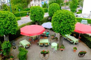 einen Blick über eine Terrasse mit Tischen und Sonnenschirmen in der Unterkunft Hotel Löwen in Kirchzarten