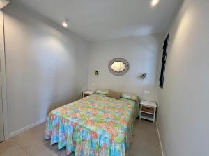 a bedroom with a bed and a round mirror at Apartmento Av Costa Blanca Playa de San Juan in Alicante