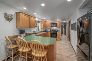 a kitchen with a green counter top and wooden cabinets at Alpine Getaway home in Leavenworth +40 photos