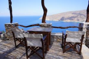 a table and chairs on a balcony overlooking the ocean at Pano Gitonia in Aegiali
