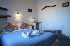 two stuffed animals are sitting on a bed at Pano Gitonia in Aegiali