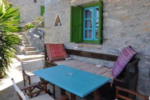 a blue table and chairs on a patio with a window at Pano Gitonia in Aegiali