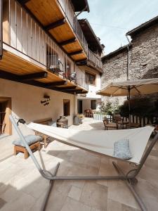 a hammock on the patio of a house at Maison de la montagne - Chambres & Relax in Arvier