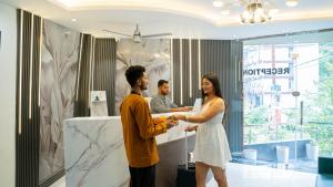 a man and a woman shaking hands in a bathroom at Perfectstayz Premium Mystic falls with Rooftop Pool & Cafe in Narendranagar +84 photos