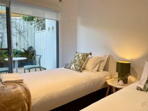 Dos camas en una habitación con balcón. en Jetty Blonde - Bright, Beachy & Perfectly Located, en Coffs Harbour 4 fotos más