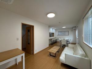 5 Minutes Train to Haneda Airport 2 Bedrooms 5 Beds Fully Equipped 2 Story Private House في طوكيو: غرفة معيشة مع أريكة وطاولة