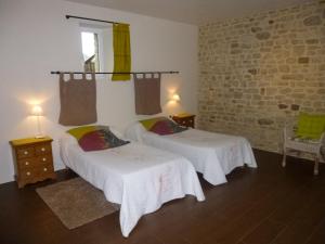 - une chambre avec 2 lits et un mur en briques dans l'établissement Chambres d'Hôtes de Céline et David, à Gahard