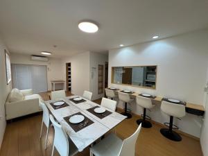 5 Minutes Train to Haneda Airport 2 Bedrooms 5 Beds Fully Equipped 2 Story Private House في طوكيو: غرفة طعام مع طاولة وكراسي في غرفة