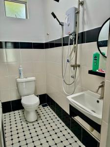 a bathroom with a shower and a toilet and a sink at EmbunSari Serimenanti Homestay 
