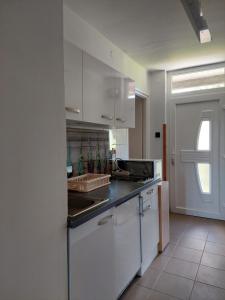 a kitchen with white cabinets and a black counter top at Dodi Apartman in Vonyarcvashegy
