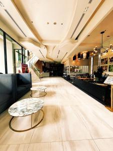 a lobby with two coffee tables and a restaurant at The Astra Condo, Downtown in Chiang Mai