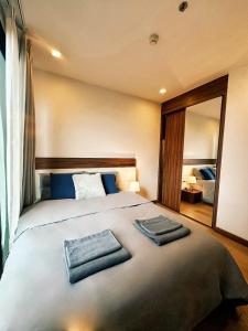 a bedroom with a large bed with two towels on it at The Astra Condo, Downtown in Chiang Mai +21 photos
