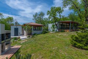 una casa con un patio con una casa en Villa Vita, a Lush Romantic Retreat in a private Forest, en Vinež