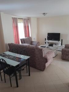 a living room with a couch and a table at Nyayo Embakasi Maisonette ZIPPYS Place in Nairobi