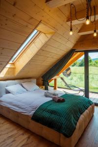 a bed in the middle of a room with an attic at Domki Na Wspólnej in Wisła