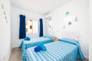 dwa łóżka w sypialni z niebieską pościelą w obiekcie Gran Sol Family 6 w mieście Felanitx