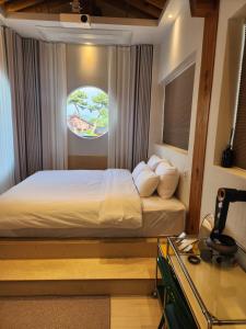 a bedroom with a bed with a desk and a window at Gyeongju central hanok in Gyeongju