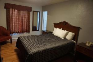 a hotel room with a bed and a mirror at Las Palmas Hotel in Los Angeles