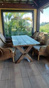 a wooden table and two chairs on a porch at Casa Vista da Pedra - 10km de Pedra Azul in Domingos Martins