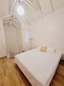 a white bedroom with a white bed and a lamp at Sandy Bay Villa Opale in Le Moule +16 photos