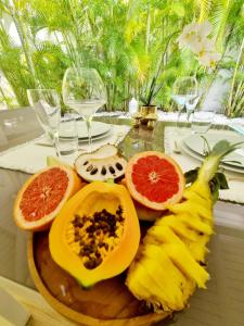 a bunch of fruit on a plate on a table at Sandy Bay Villa Opale in Le Moule