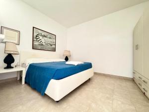 a bedroom with a bed with a blue blanket at FA Appartamenti Rurali in Galatone