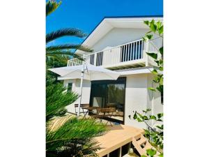a white house with a balcony and some trees at Kanae - Vacation STAY 96254v in Tateyama