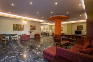 a lobby with couches and a table and chairs at Popi Star in Gouvia