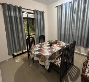 a dining room with a table and chairs and a window at Diva Gomes Guest House in Nuvem