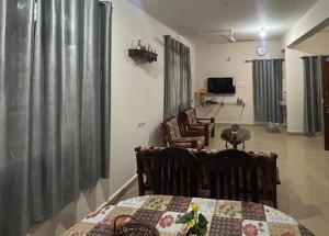 a room with a table and chairs and a living room at Diva Gomes Guest House in Nuvem