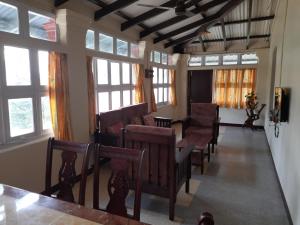 uma sala de estar com cadeiras e janelas em Spring Haven Yercaud em Salem