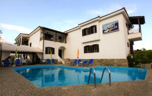 a hotel with a swimming pool in front of a building at Hotel Sylvia in Koinyra