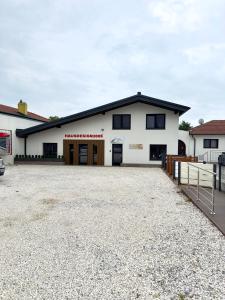 ein weißes Gebäude mit schwarzen Fenstern und einer Auffahrt in der Unterkunft Stork Apartment in Sankt Margarethen im Burgenland
