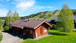 a small house with a roof on a green field at Villa Kastanja - 8 henkilölle, Himoslaakso Ski-inout in Jämsä