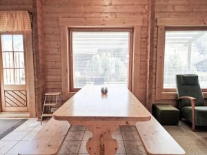 a wooden table in a room with two windows at Villa Kastanja - 8 henkilölle, Himoslaakso Ski-inout in Jämsä +19 photos