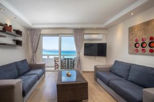 a living room with a couch and a tv at Molos Seaside Apartment in Rhodes Town