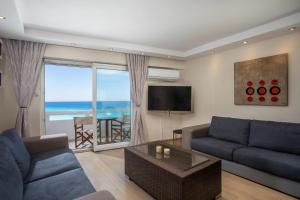 a living room with a blue couch and a television at Molos Seaside Apartment in Rhodes Town