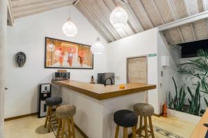 a kitchen with a bar with stools around it at Villa Cemacase in Cemagi