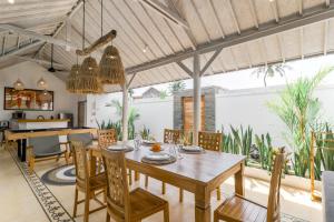 an open kitchen and dining room with a wooden table and chairs at Villa Cemacase - Stylish 2BR Villa with Spacious Private Pool & Pool Table in Seseh in Cemagi