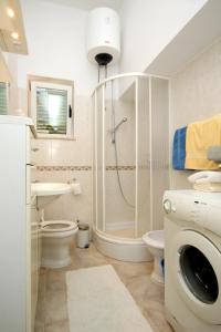 a bathroom with a shower and a toilet and a washing machine at Seaside family friendly house with a swimming pool Mlini, Dubrovnik - 2145 in Mlini