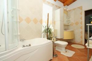 a bathroom with a white tub and a toilet at Seaside family friendly house with a swimming pool Mlini, Dubrovnik - 2145 in Mlini +21 photos