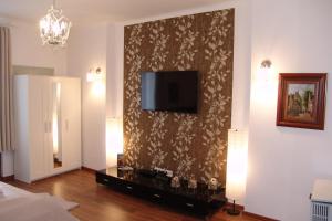 a living room with a television on a wall at Romantic Centrum Apartman in Budapest