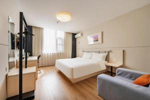 a hotel room with a bed and a couch at JinJiang Inn Baoji Administra Tion Center in Baoji +214 photos