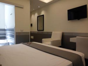 a bedroom with a bed and a flat screen tv at Mina Accomodation in Tropea